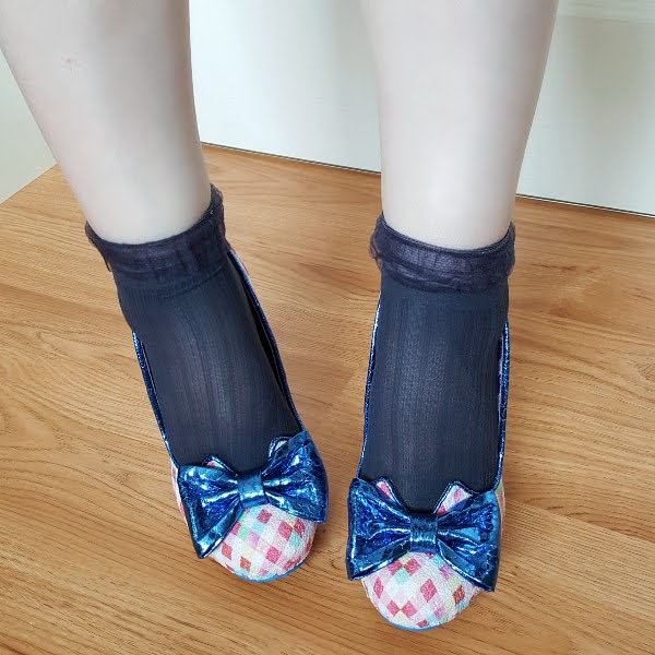 wearing navy ankle socks and gingham court shoes with metallic blue bow on toe