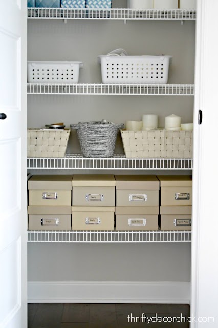 organized linen closet with photo boxes