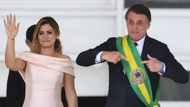 Jair Bolsonaro junto a su esposa luce la banda presidencial de Brasil / AFP