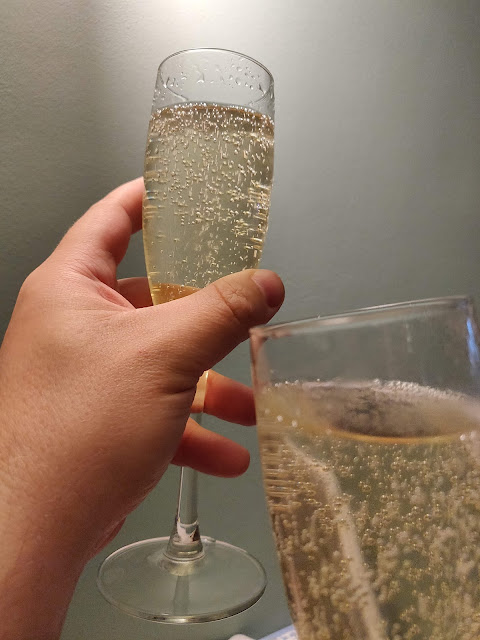 A hand raising a glass of Prosecco