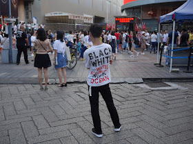 young man wearing "Black White; Water Accumulates Into The Ocean" shirt
