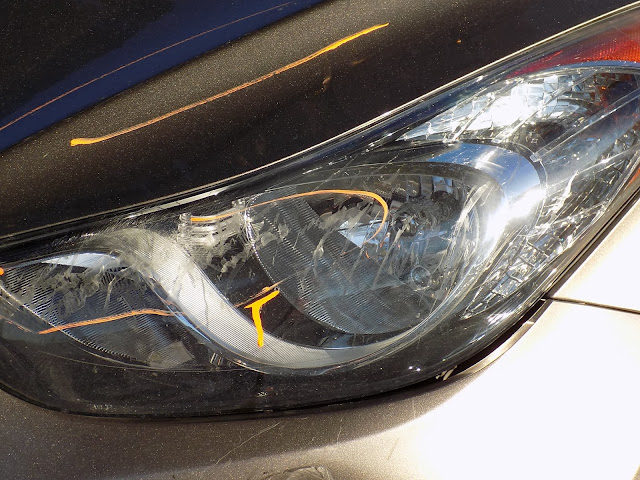 Scraped headlight before replacement at Almost Everything Auto Body.