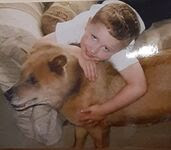 Young boy hugging dog