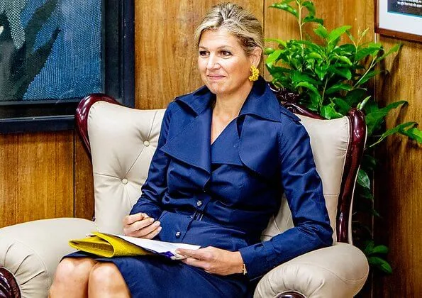 Queen Maxima wore a navy blue trench dress by Jan Taminiau. yellow earrings and Gianvito Rossi yellow metallic pumps