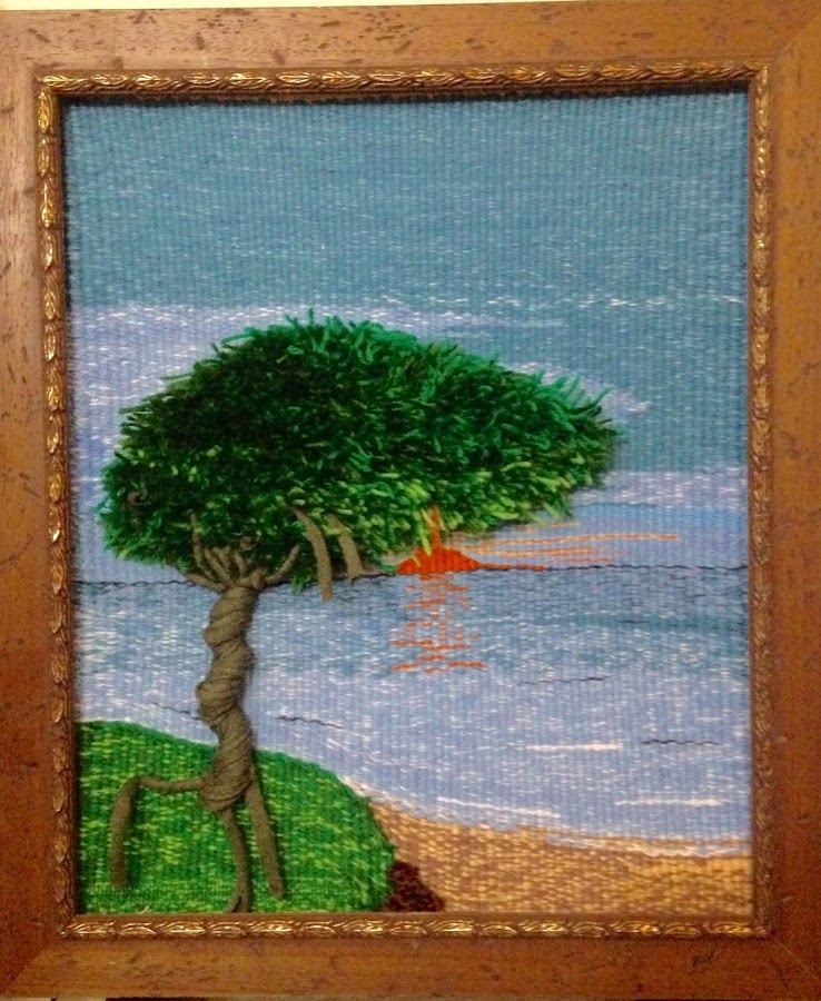 Tapiz de alto lizo realizado sobre un marco y trabajado por la parte de atras, con lana y algodón. Árbol en relieve con puesta de sol y un bonito mar azul