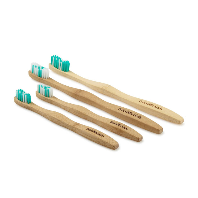 Picture of 4 toothbrushes. There are 2 adult ones and 2 child brushes. The brushes have green and white bristles and a bamboo handle.