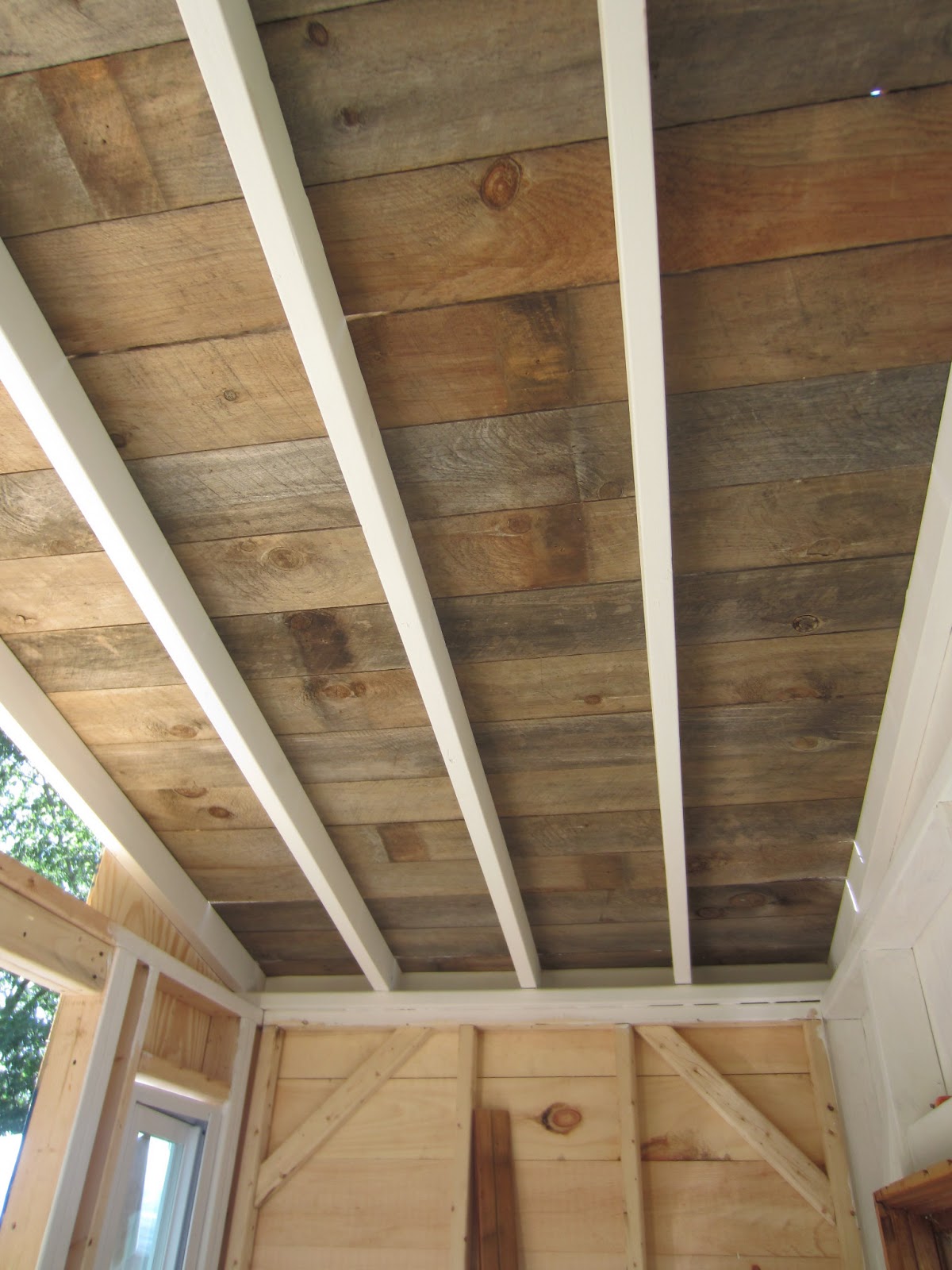 A recycled barn wood/fence plank ceiling in a tiny