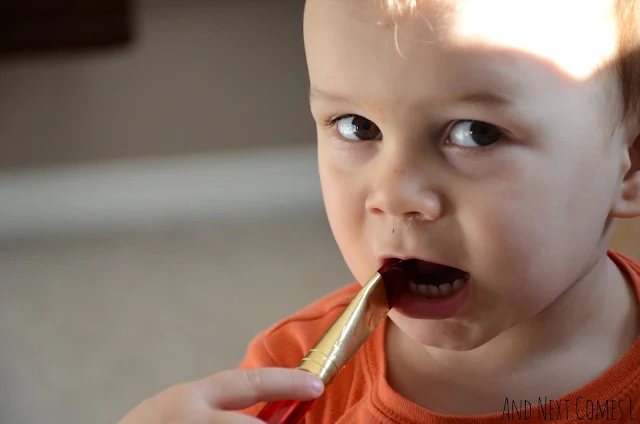 Toddler chewing on paint brush