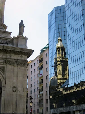 Colonial building reflected in a modern glass building on Plaza de Armas in Santiago Chile