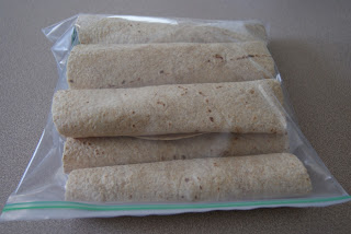 A plastic bag of turkey, cheese and lettuce tortilla wraps.