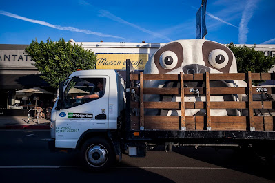 The head of the museum's bulldog building being trucked down a city street.