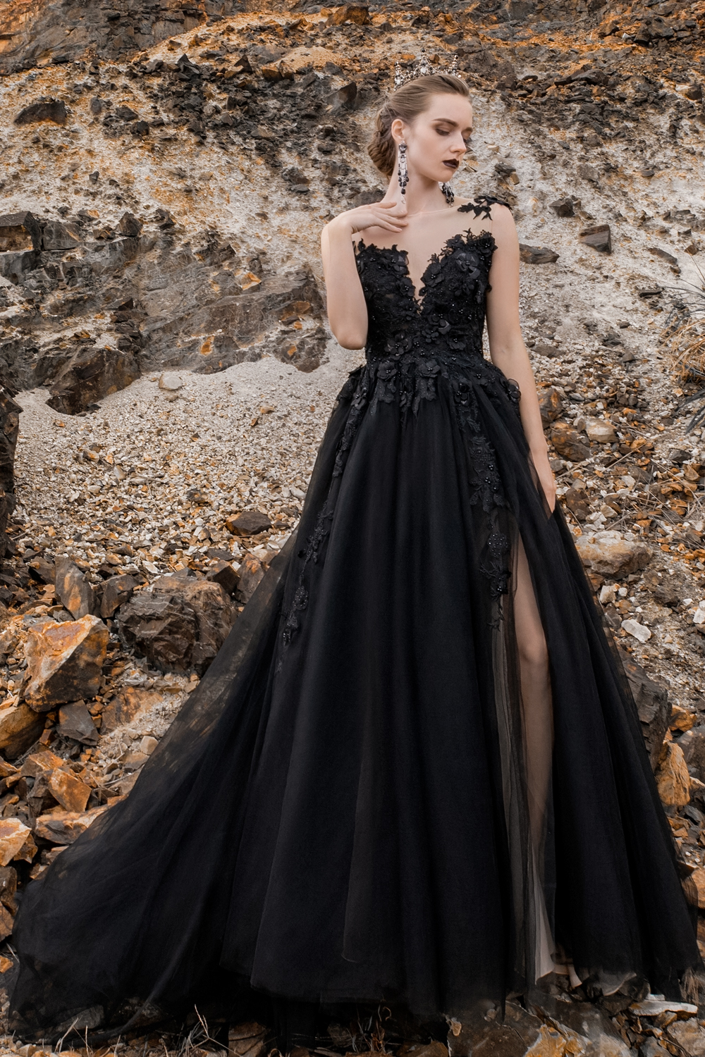 a qoman in a black wedding dres is posing on a coast