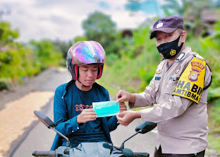 Harapkan Warga Tetap Taat Prokes, Bhabinkamtibmas Polsek Enrekan Bagikan Masker