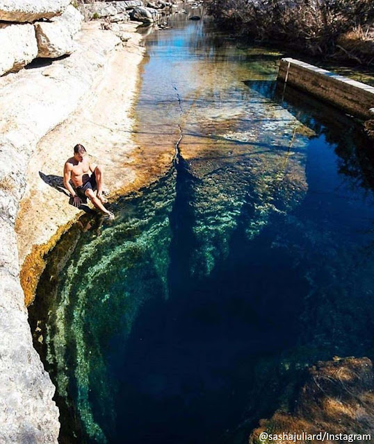 un hombre a orillas del pozo de jacob, agua trasparente permite ver profundidad