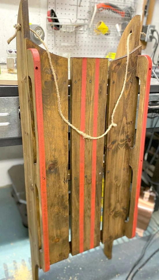 Red striped lines on a wooden stained sled