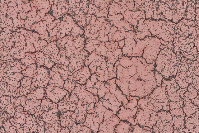 Red paint cracked on road texture