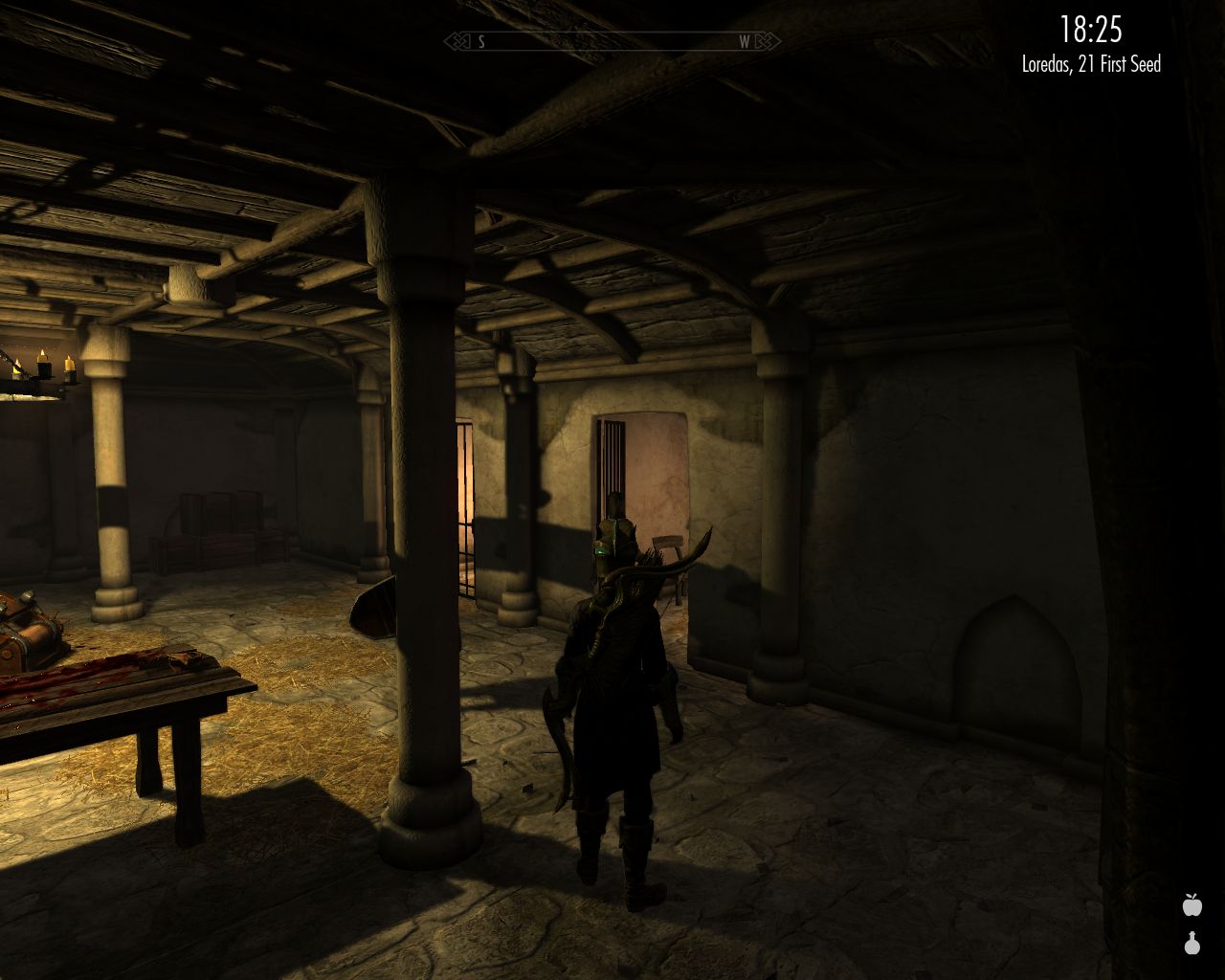 Laura stands in the hall with a low wooden ceiling looking at an open cell door