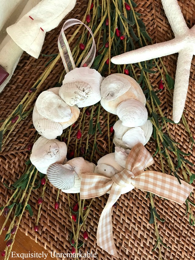 Coastal Christmas Shell Wreath Ornament on wicker placemat