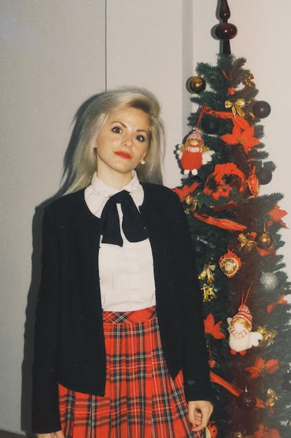 Alejandra Colomera con lazo negro en el cuello, camisa, blanca, chaqueta negra y falda tartán roja