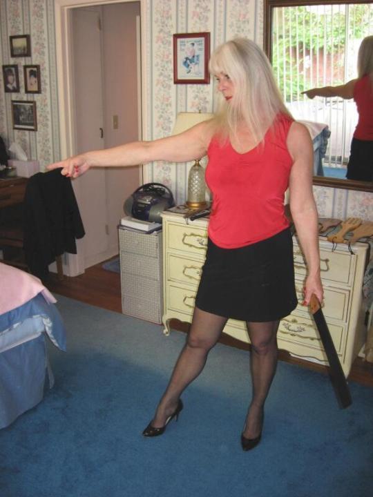 Strict woman wearing skirt, pantyhose and high heels
