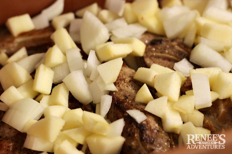 Chopped Apples and onions on seared country style ribs in roasting pan