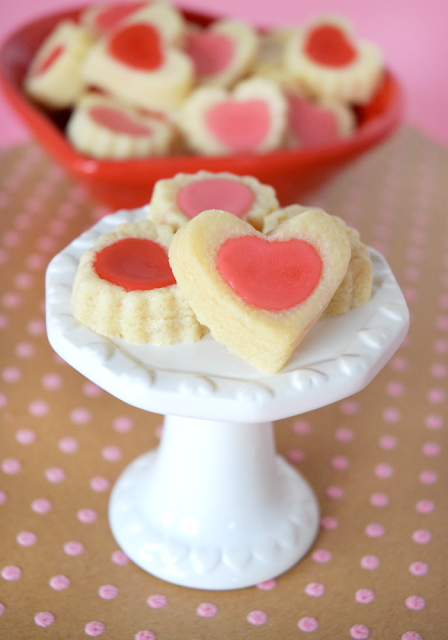 Sweet heart shaped tea cookies for Valentine's Day. Melt in your mouth buttery shortbread with a dab of sweet pink frosting in the center! Perfect for class parties or a tea party!