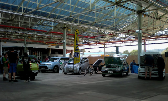 A row of electric vehicles on display including a solar taxi.