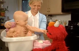 there is a baby being bathed by his mother in a small tub. Elmo explains that a baby needs water and mommy to take a bath. Sesame Street Elmo's World Bath Time Kids and Baby