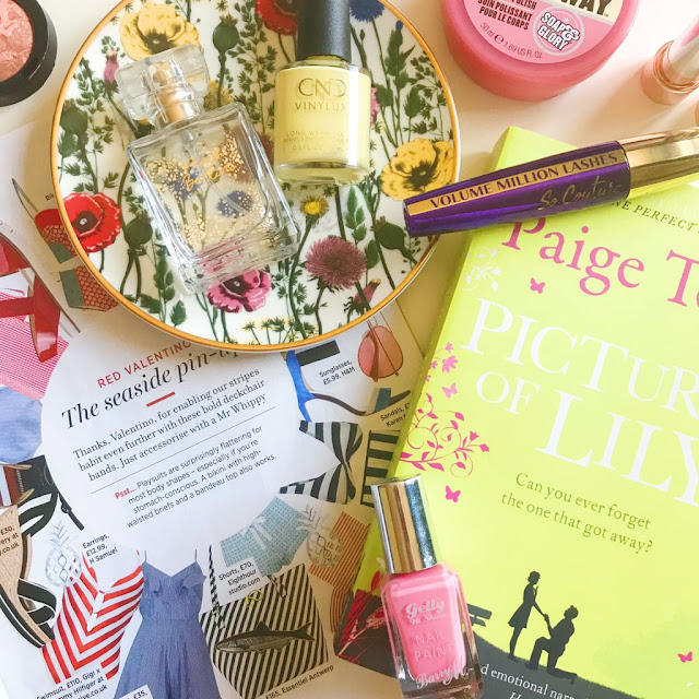 flatlay - magazine to the bottom left corner, Paige Toon Pictures Of Lily book to the right. Flower trinket dish top left corner. New Look Peach Belini perfume placed on top with a CND nail polish next to it