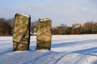 A snowy stone sculpture about football with St James park in the background