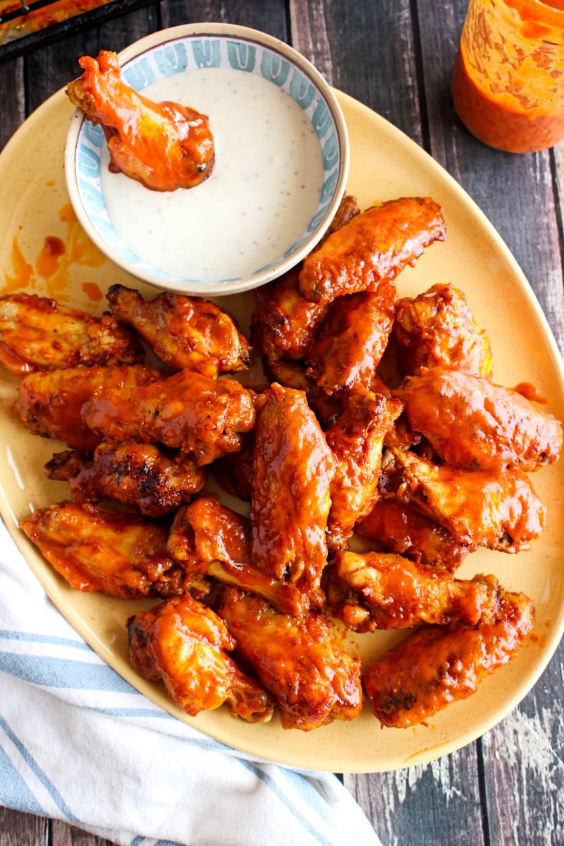 Top view of Baked Buffalo Chicken Wings on a yellow plate on a wood background.