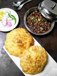 Serving chole bhature with onion, lemon slice and green chili for chole bhature recipe