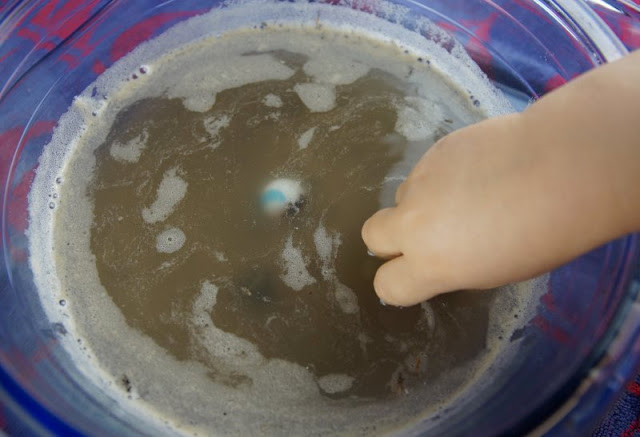 Spiele-Idee für den Kindergeburtstag: Die Murmel-Schatzsuche im Matschbad. Mit dem Pinzettengriff fischen die Kinder die Murmeln sicher aus dem Wasser-Sand-Gemisch. So wird der Kindergeburtstag ein Erfolg!