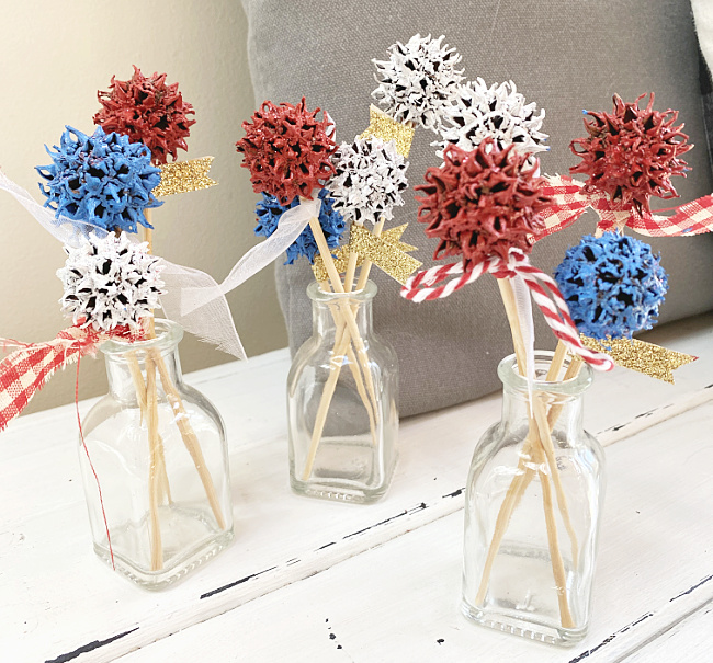 little vases with red, white, and blue sweet gum flowers