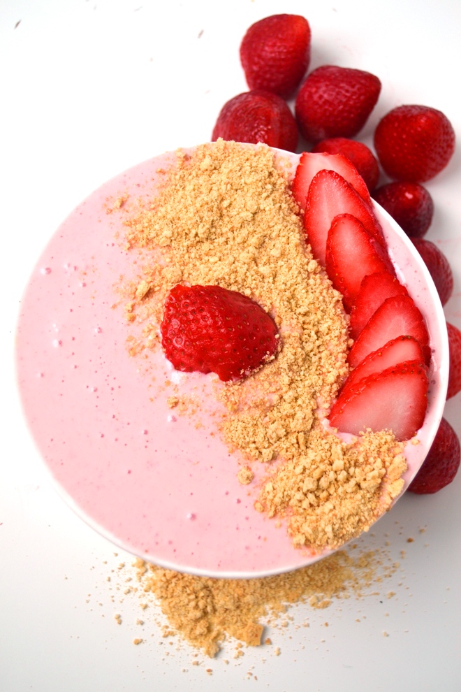 Strawberry Cheesecake Smoothie Bowl is a 5-minute nutritious treat that tastes like your favorite cheesecake and is topped with sliced strawberries and graham crumbs! www.nutritionistreviews.com