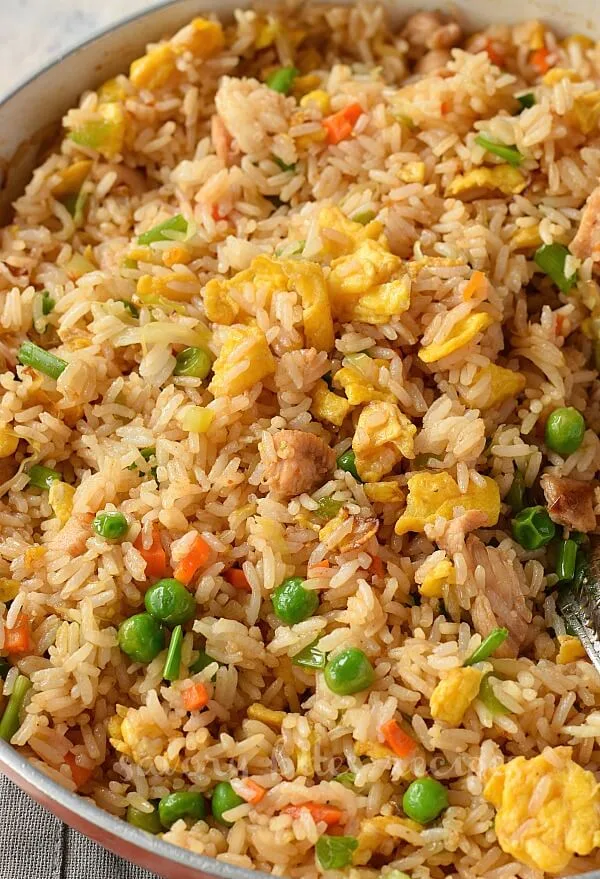 a skillet with best chicken fried rice with eggs,chicken,carrots,peas