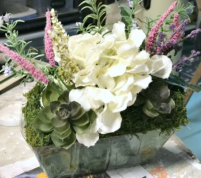 Faux flowers in a foam basket