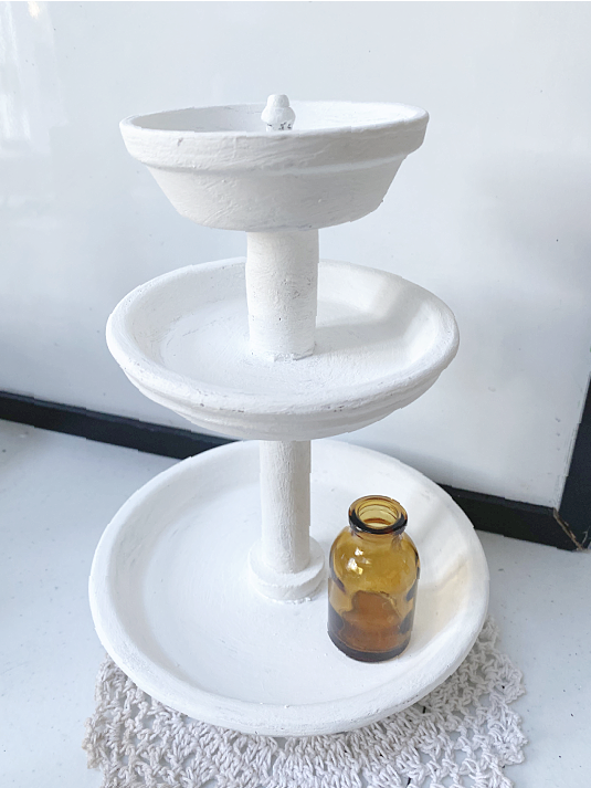 white tiered tray with amber bottle