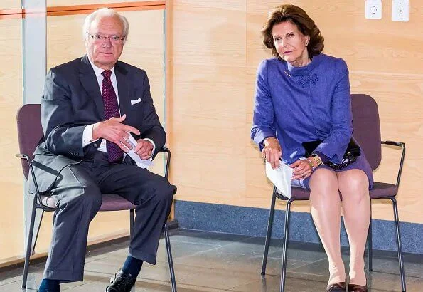 Queen Silvia wore and blue jacket and skirt, skirt suit. She is wearing gold earrings and gold bracelet