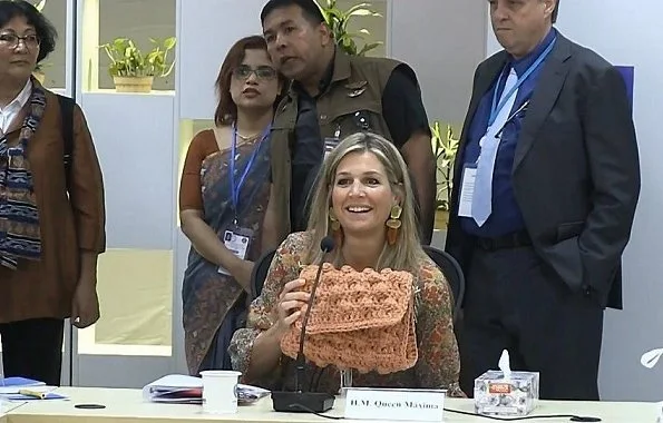 Queen Maxima wore a floral print silk blouse and floral print silk midi skirt, and Ntan pumps, fruit earrings, One & Only clutch