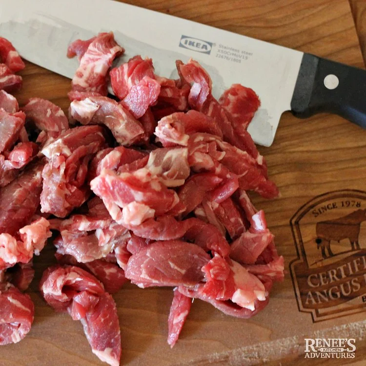 Process photos of cut up raw beef on cutting board with a knife for Spicy Chinese Beef Noodle Soup by Renee's Kitchen Adventures