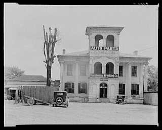 A large black and white image of The Drish House structure with Auto Parts Banner on it