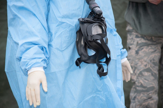 A doctor in protective gear, photo taken from the shoulders down.