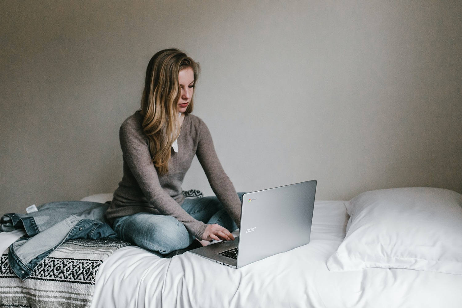 woman is using laptop on a bed