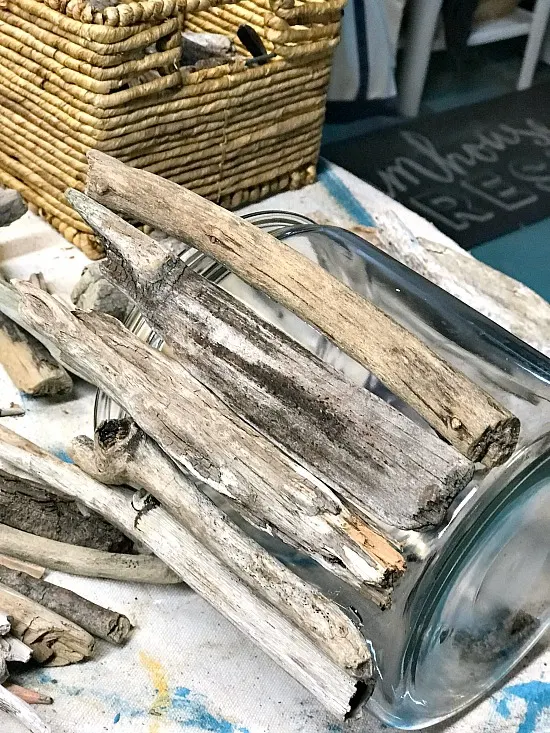 Driftwood lined up on the outside of a glass vase