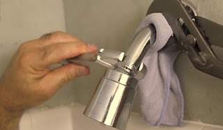 using a wrench on a shower head