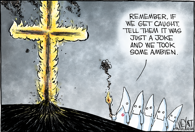 Group of KKK members standing around a burning cross.  One says, 