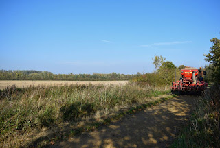 A farm vehicle along a narrow track next to fields