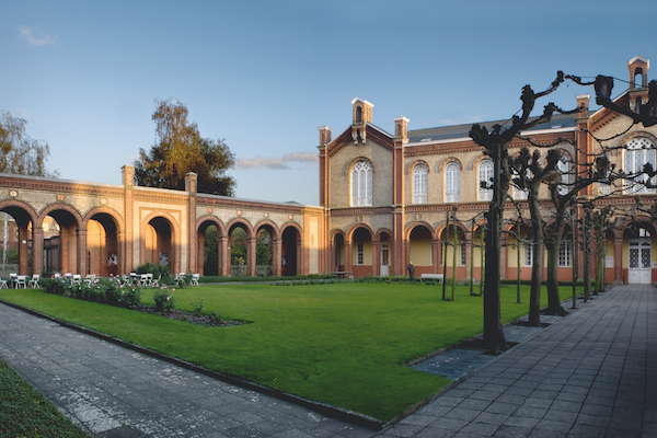 The museum’s central court and one wing of the nineteenth-century buiding. The court has a green lawn, several trees, roses and a terrace. © 2012, Guido Suykens.