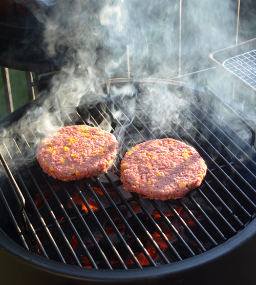 Grilling cheesy half-pound burgers on the Oklahoma Joe's Bronco drum smoker